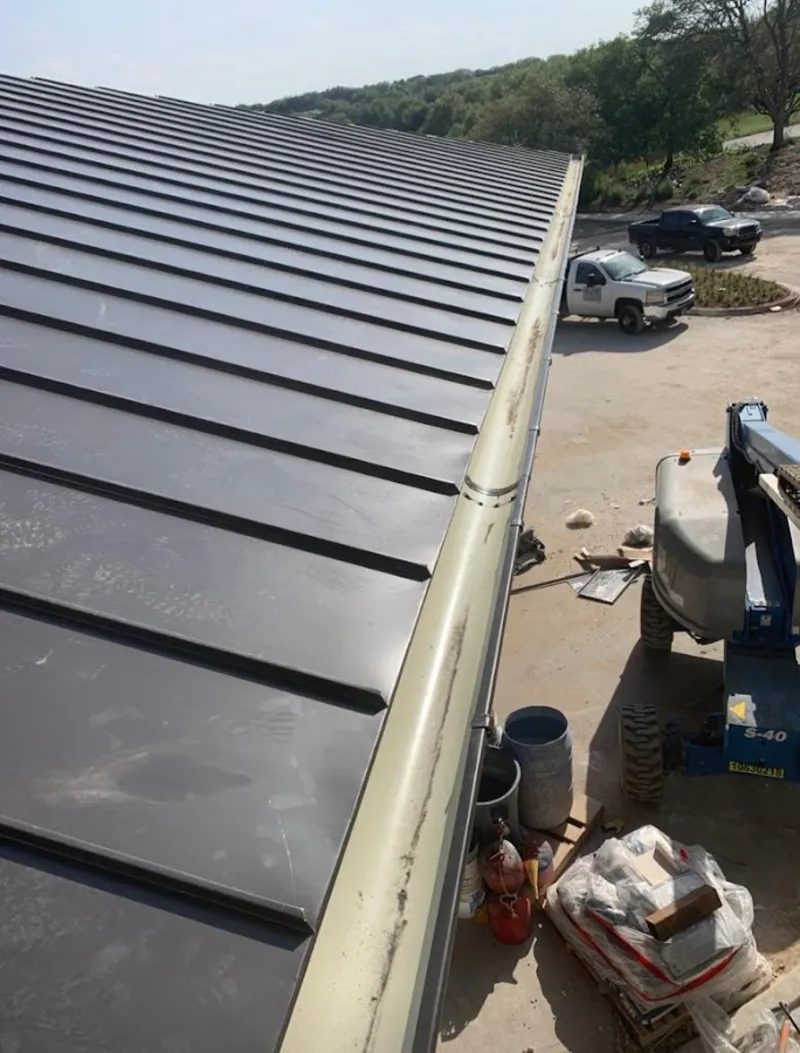 Standing seam panel and gutter detail on a metal roofing jobsite in Lyons
